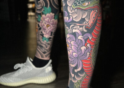 Japanese traditional tattoo full leg sleeve of green cobra and purple chrysanthemum