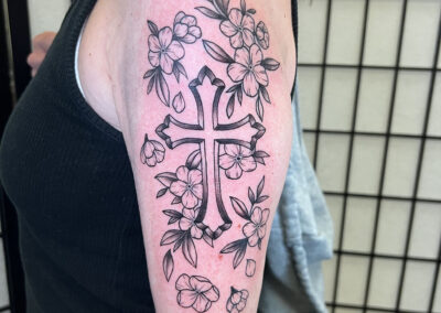 black and gray cross with flowers tattoo
