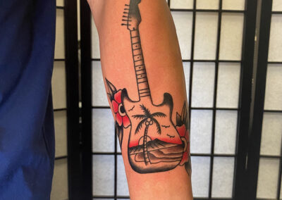 american traditional tattoo of guitar with palm tree
