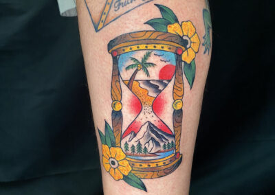 American traditional tattoo of an hour glass with yellow flowers