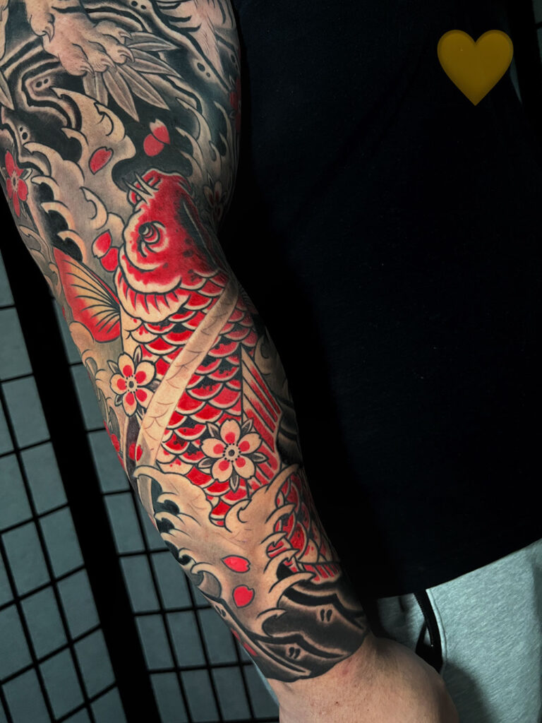 Japanese Traditional tattoo of red koi with water and rocks background full sleeve