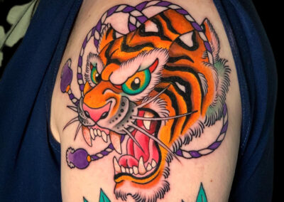 Japanese Traditional tattoo of open mouth tiger head with traditional cords in background