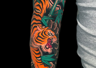 Japanese Traditional tattoo of a full body open mouth tiger with bamboo full sleeve