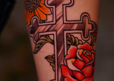 American traditional cross with sunflower and rose tattoo
