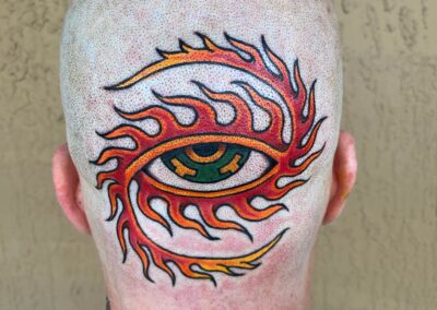eye with red flames on back of head tattoo