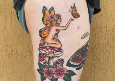 fairy with butterfly wings sitting on mushroom tattoo