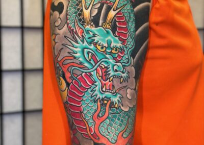 Japanese traditional full sleeve of green dragon with red belly wind bars and maple leaves