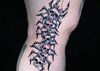black and gray centipede made of skulls tattoo