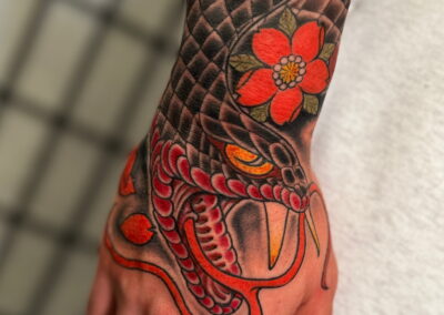 Japanese traditional open mouth snake with cherry blossoms tattoo on hand