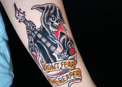American Traditional tattoo of reaper playing the guitar