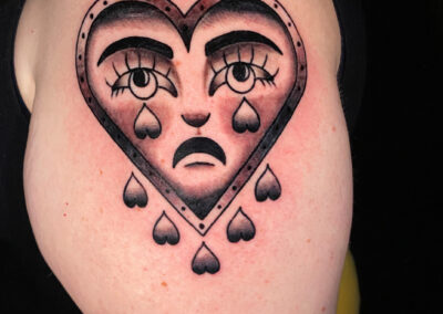traditional heart with face crying tattoo